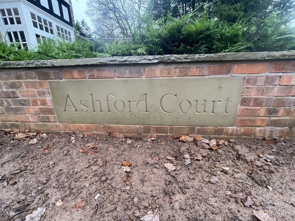 Hand-cut Ashford Court name stone set into a brick wall